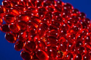 red medical capsules on a mirror surface
