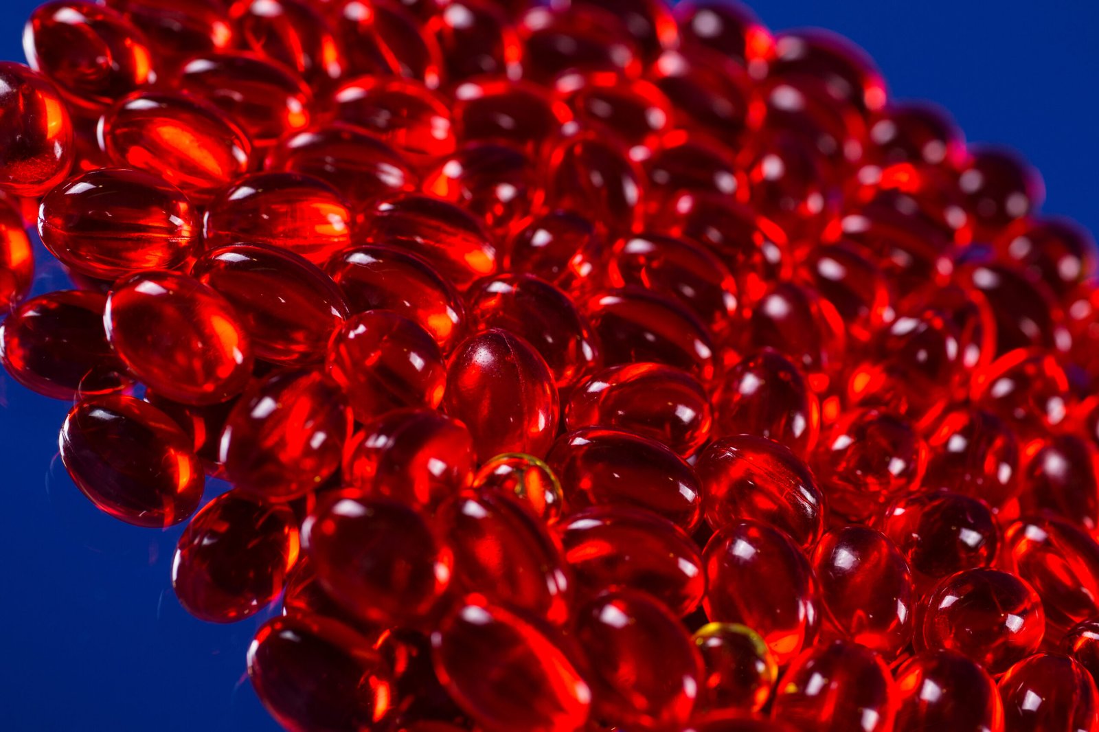 red medical capsules on a mirror surface